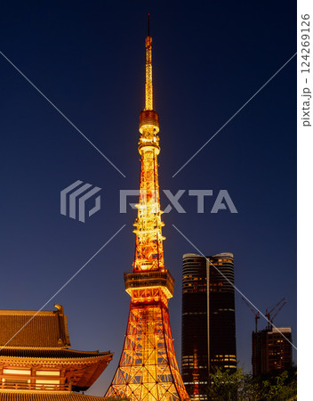 Tokyo Tower glows at night with golden lights standing between the historic Zojo-ji Temple Tokyo Tower glows at night with golden lights standing between the historic Zojo-ji Temple 124269126