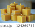 A collection of beeswax candles in various sizes radiates a warm glow in a bright room, creating a soothing and inviting ambiance for relaxation or meditation Generative AI 124269735
