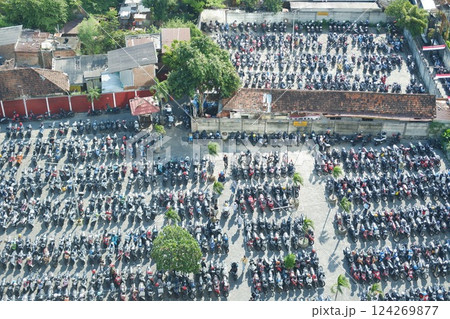 a densely packed motorcycle parking lot in an urban area a densely packed motorcycle parking lot in an urban area 124269877