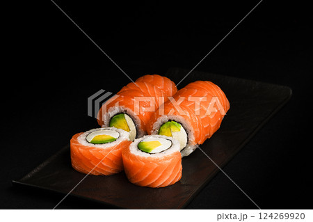 Delicious Fresh Salmon Sushi Rolls Presenting Exquisitely on a Black Background Delicious Fresh Salmon Sushi Rolls Presenting Exquisitely on a Black Background 124269920