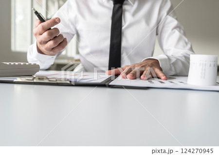Busy financial adviser working at his business desk with many documents 124270945