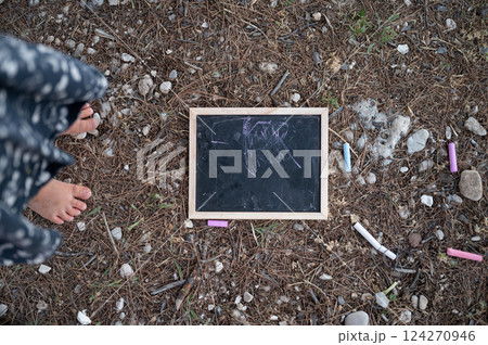 Chalk board and chalks on the ground 124270946