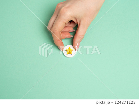 The hand holds a gold star. Distinction. Rating and recognition. Achievement. Top ratings in professional or educational settings. 124271125