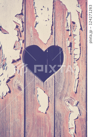 A heart shape cut out of a wooden board with peeling paint. A heart shape cut out of a wooden board with peeling paint. 124271263