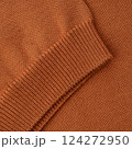 Elastic band close up on the sleeve of a terracotta orange knitted cotton polo t-shirt 124272950