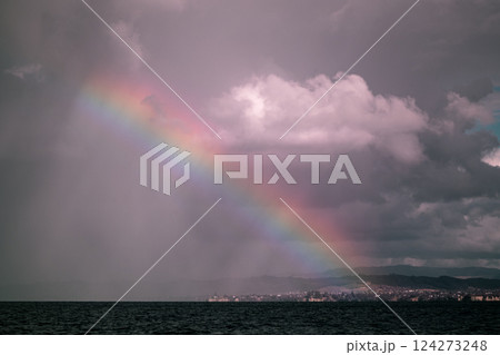 Bright rainbow over the ocean after a rainstorm, New Zealand 124273248