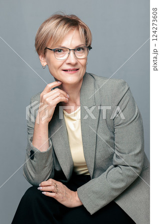 Portrait of happy woman. Confident, successful mature woman on light gray background. Looking at camera. High quality photo Portrait of happy woman. Confident, successful mature woman on light gray background. Looking at camera. High quality photo 124273608
