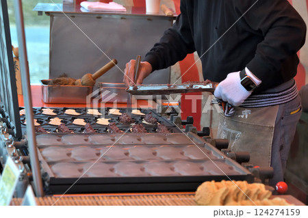 神社の祭り 屋台グルメ たい焼きを焼く職人の手元 神社の祭り 屋台グルメ たい焼きを焼く職人の手元 124274159