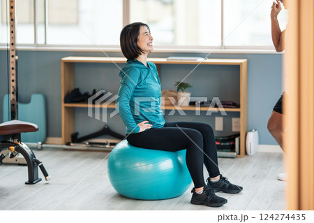 スポーツジムでバランスボールに乗る女性 スポーツジムでバランスボールに乗る女性 124274435