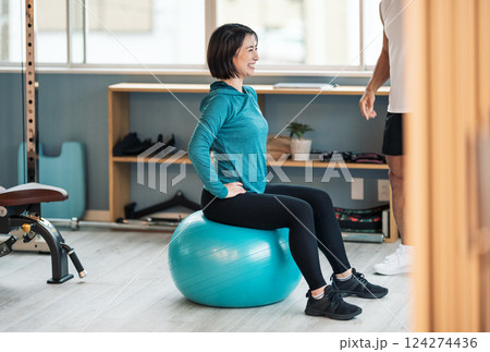 スポーツジムに通いバランスボールで体幹を鍛える女性 124274436