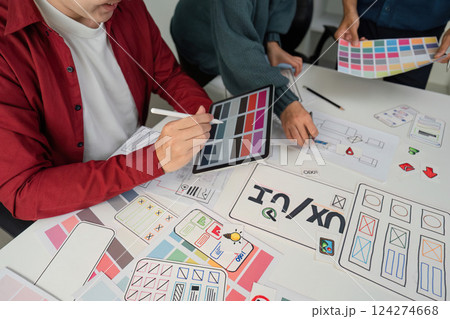 Creative Collaboration and Design Prototyping. Team members engaged in a lively session, refining design ideas using digital tools and paper prototypes. Creative Collaboration and Design Prototyping. Team members engaged in a lively session, refining design ideas using digital tools and paper prototypes. 124274668