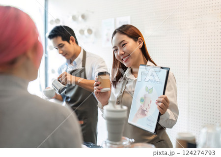 Sustainable Practices and Friendly Service. A barista showcases eco-friendly initiatives while serving coffee. Sustainable Practices and Friendly Service. A barista showcases eco-friendly initiatives while serving coffee. 124274793