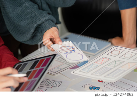 User Experience Design and Presentation. Designers showcasing mobile user interface layouts while discussing project ideas. 124274862