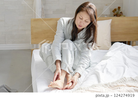 パジャマを着た中年の女性　足のリウマチ　冷え性 124274919
