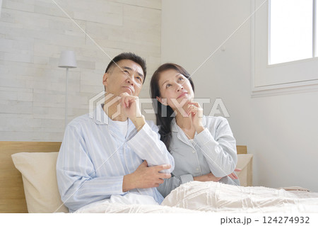 考えるパジャマを着た夫婦 124274932