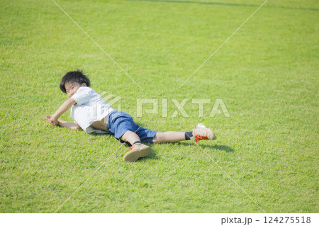 芝生に寝転がる男の子　 124275518