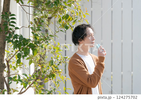 庭でタバコを吸う男性 124275702