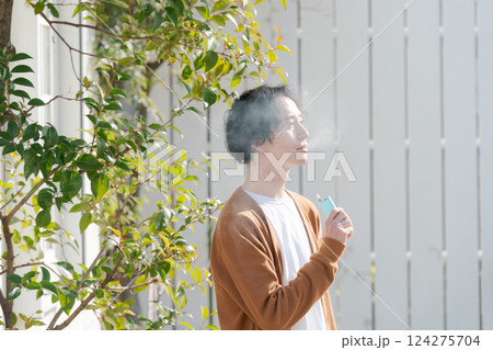 庭でタバコを吸う男性 124275704