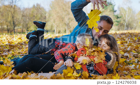 Family playing with golden leaves, laughing and bonding during sunny autumn afternoon in vibrant park setting, sharing warm moment Family playing with golden leaves, laughing and bonding during sunny autumn afternoon in vibrant park setting, sharing warm moment 124276038