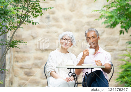 ベンチに座ってお茶を飲むシニア夫婦 124276267