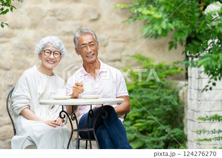 ベンチに座ってお茶を飲むシニア夫婦 124276270