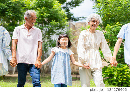 孫と手を繋いで歩くシニア夫婦 124276406