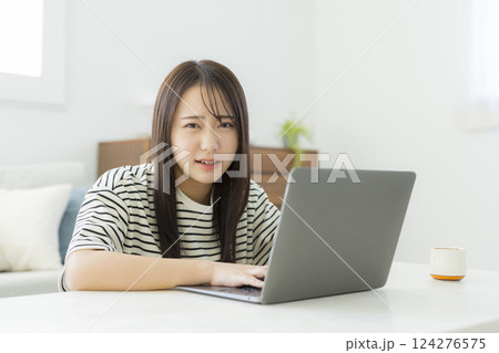 リビングでパソコンを使う若い女性 リビングでパソコンを使う若い女性 124276575
