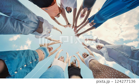 School friends joining hands in a circle, raising arms in celebration of their unity and friendship 124277136