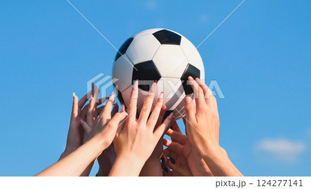 School friends holding a soccer ball against a blue sky, symbolizing teamwork, unity, and passion for sports School friends holding a soccer ball against a blue sky, symbolizing teamwork, unity, and passion for sports 124277141
