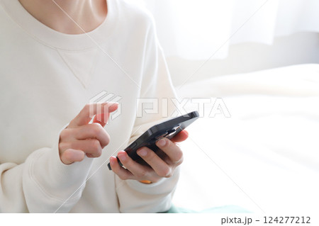 スマホを使う手元 124277212