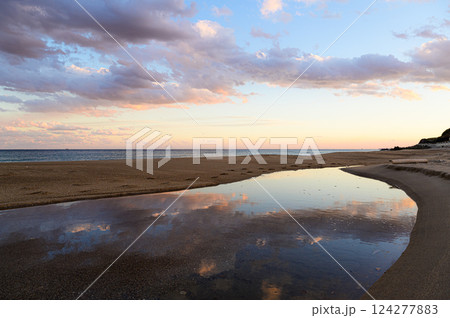 夕焼けに染まる雲と水面に映る空 124277883