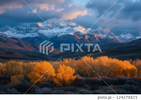 Golden Autumn Trees Against Snowy Mountain Backdrop 124278815