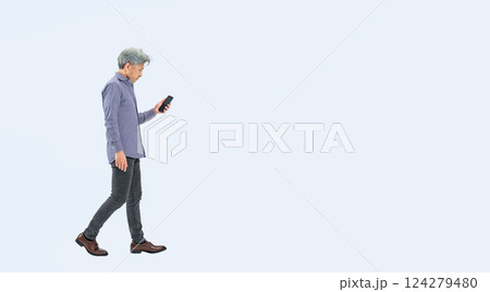 スマホを見ながら歩くシニア男性の全身写真 124279480
