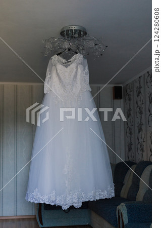 Beautiful white wedding dress hanging on the Beautiful white wedding dress hanging on the 124280608