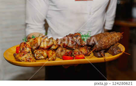 Shish kebab from different types of meat lies on a Shish kebab from different types of meat lies on a 124280621