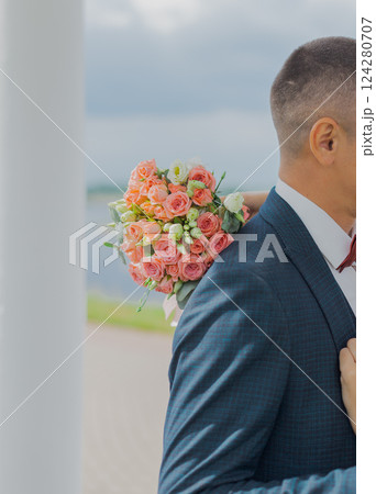 Beautiful young bride holding a bouquet in her 124280707