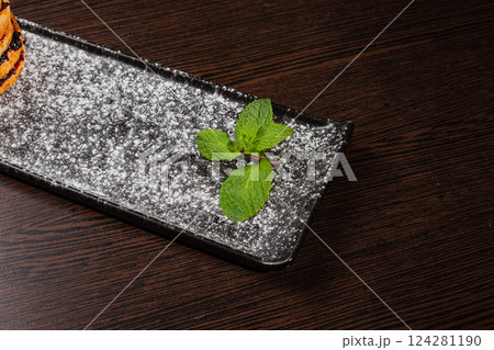 Appetizing fresh dessert cake on a black plate Appetizing fresh dessert cake on a black plate 124281190