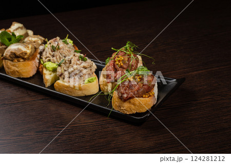 Three types of bruschetta on the table on a black Three types of bruschetta on the table on a black 124281212