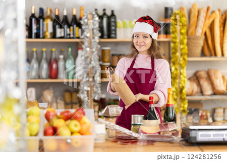 Salesgirl in Santa hat recommending wine on New Years Eve Salesgirl in Santa hat recommending wine on New Years Eve 124281256