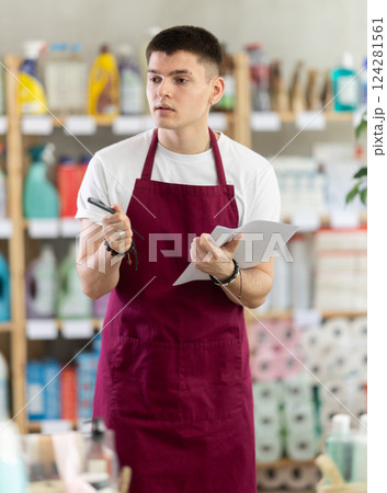 Young man seller conducting inventory in store Young man seller conducting inventory in store 124281561
