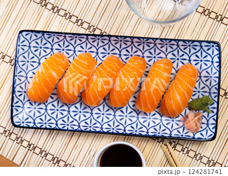 Sake nigiri - dietary sushi with salmon and tuna, soy sauce closeup 124281741