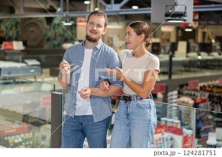 Couple man and woman looking around in building store Couple man and woman looking around in building store 124281751