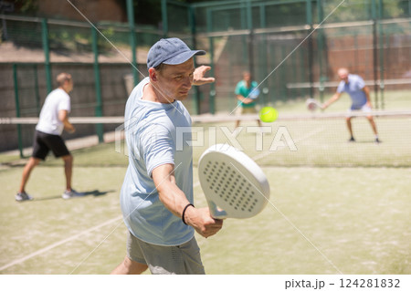 Men play padel on an outdoor tennis court. Hitting the ball with racket Men play padel on an outdoor tennis court. Hitting the ball with racket 124281832