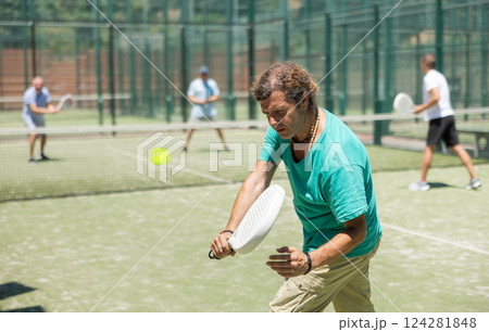 Male player serving ball during training padel in court Male player serving ball during training padel in court 124281848