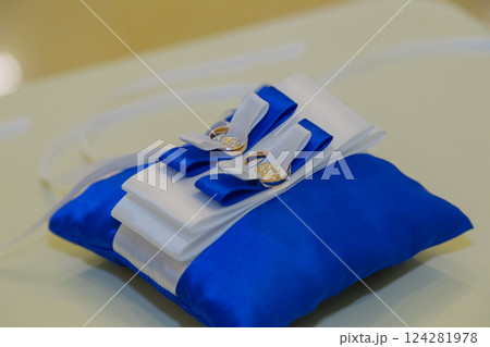 Two beautiful gold rings on a small pillow at a 124281978