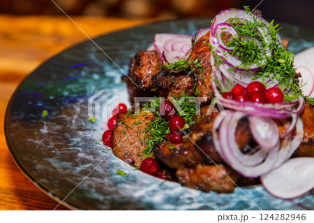 Grilled meat with baked vegetables on a plate on a 124282946