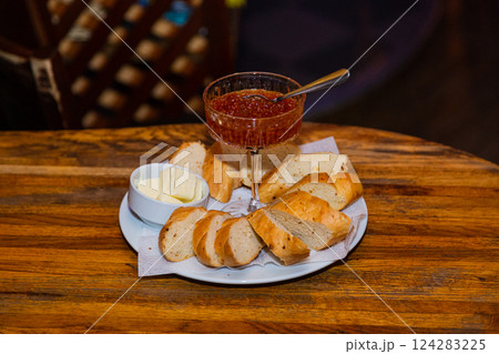 Glass bowl with salmon caviar on a tray with bread Glass bowl with salmon caviar on a tray with bread 124283225