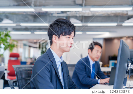 オフィスでモニタに向かって働くビジネスマン 124283878