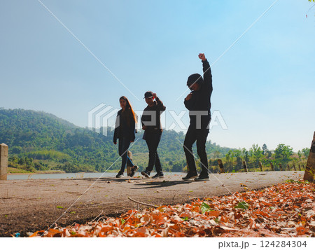 silhouette hiker friend group walk together on street with lake and forest background 124284304