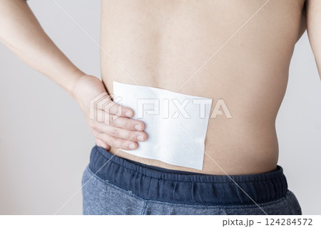 腰に湿布を貼る男性　腰痛　湿布　筋肉痛 124284572